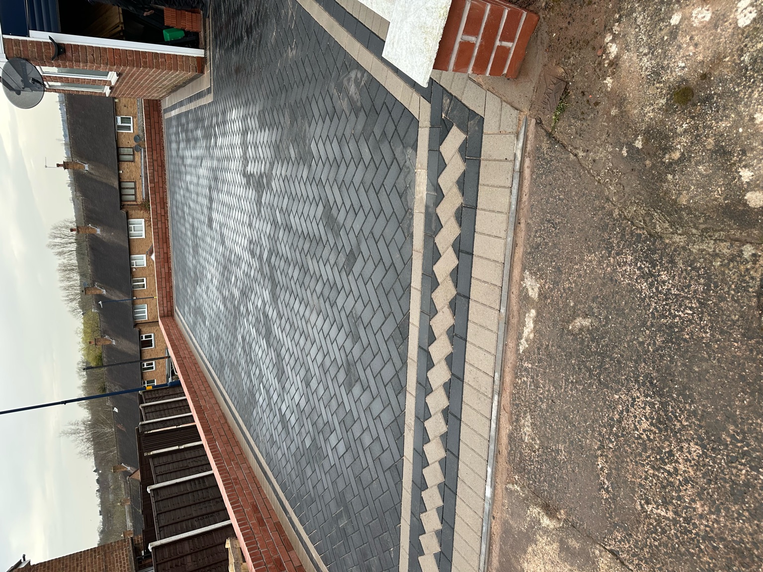 Grey herringbone block paved driveway with a zigzag feature border