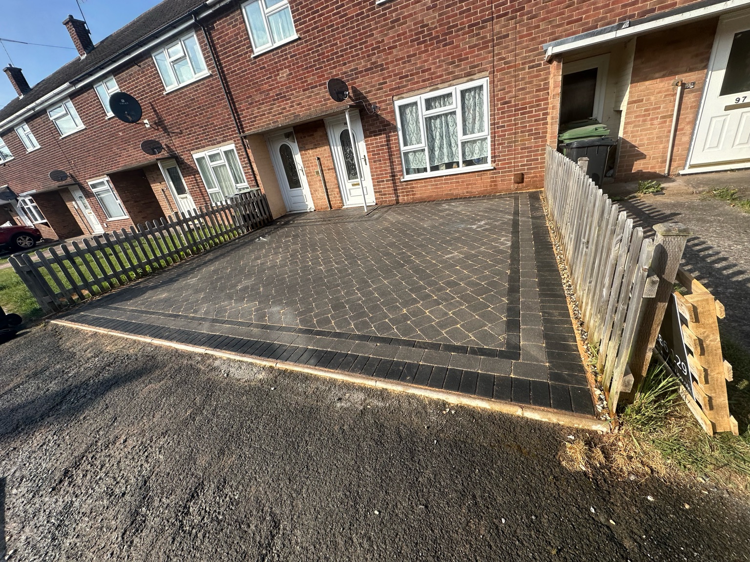 Block paved driveway with a black border at a red brick terraced house in Worcester